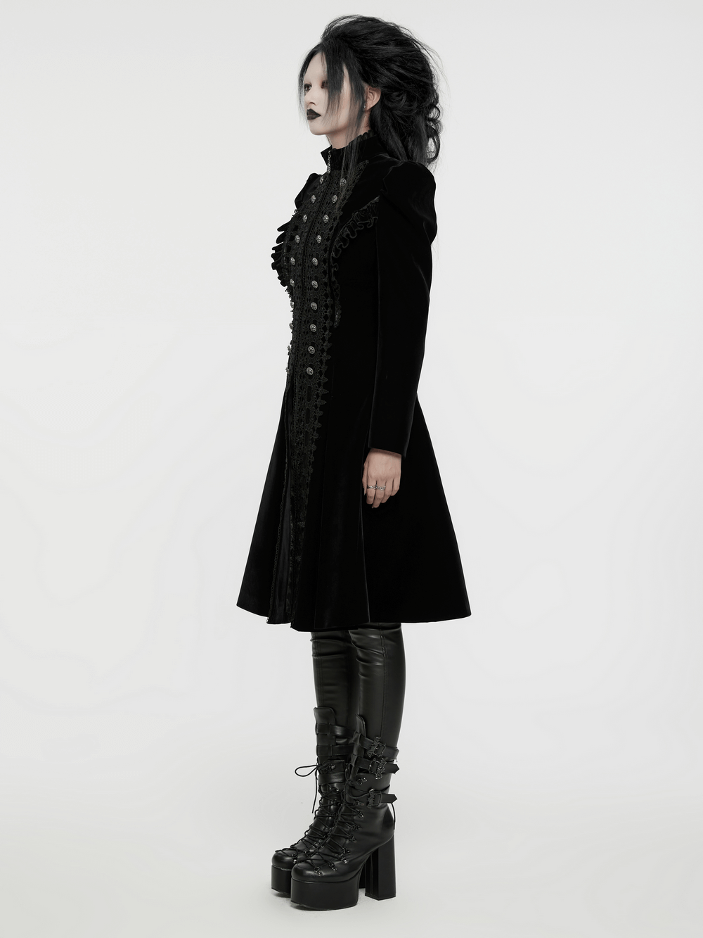 Elegant black velvet Gothic coat with lace panels and ruffles, paired with stylish platform boots.