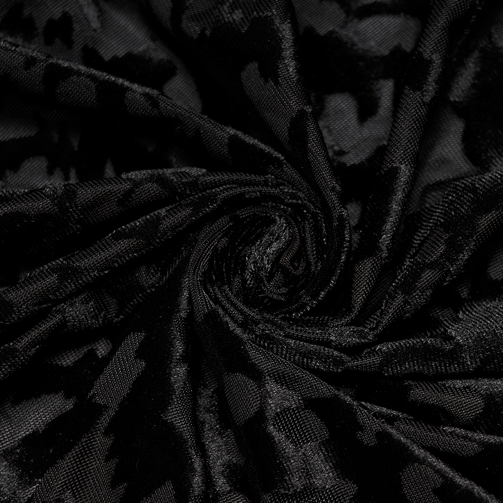 Close-up of black velvet fabric with an abstract bat pattern, perfect for gothic clothing designs.