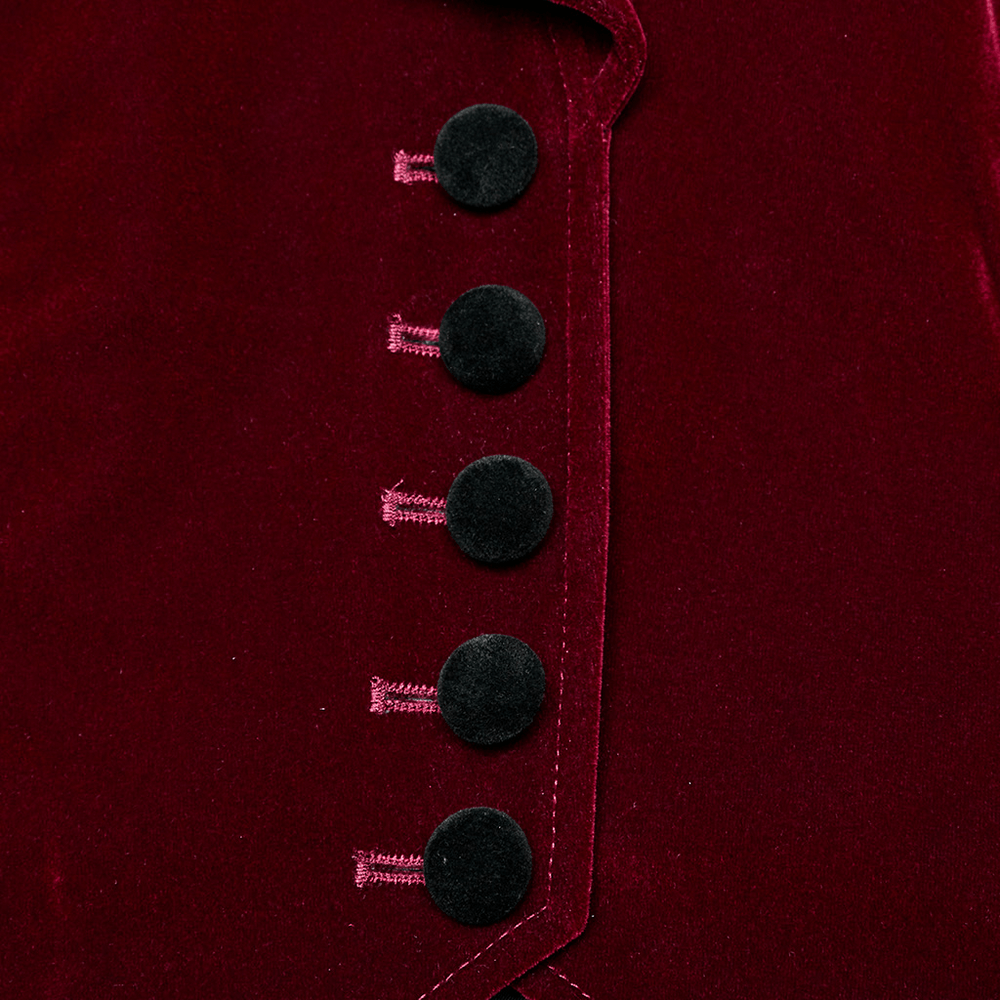 Close-up of elegant black buttons on a luxurious velvet gothic jacket, showcasing fine embroidery and rich texture.
