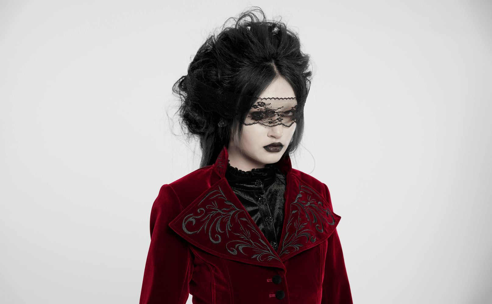 Elegant model in a Gothic velvet embroidered tailcoat with lace veil and stand collar design.