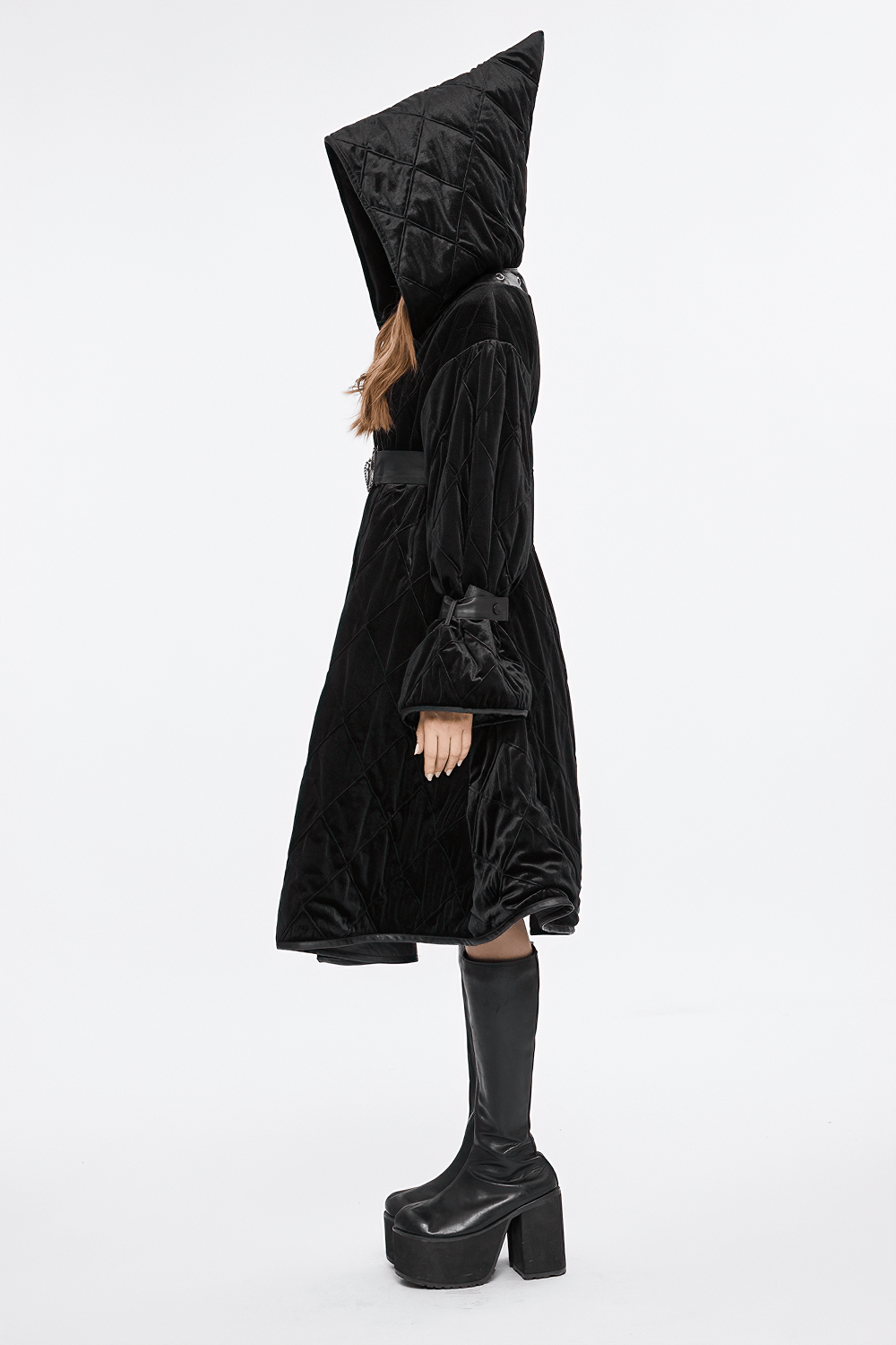 Side view of a woman in a velvet gothic hooded coat with a detachable leather belt, exuding stylish mystique.