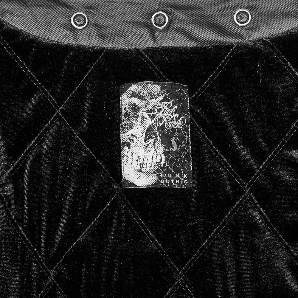 Close-up of a skull design label on a velvet gothic coat, showcasing unique texture and intricate details.