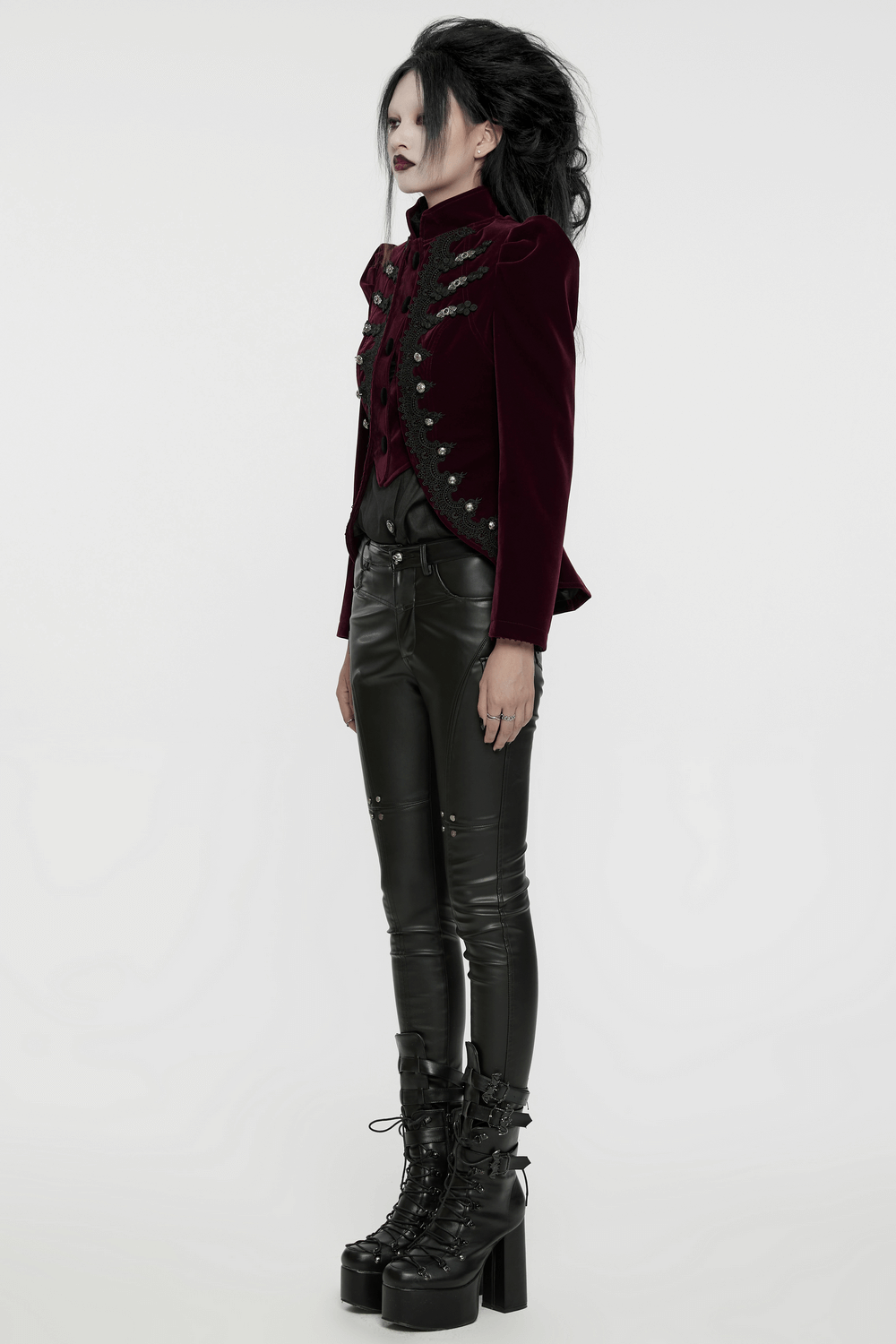 Luxurious velvet gothic jacket with lace-up back, intricate appliques, paired with sleek black pants and platform boots.