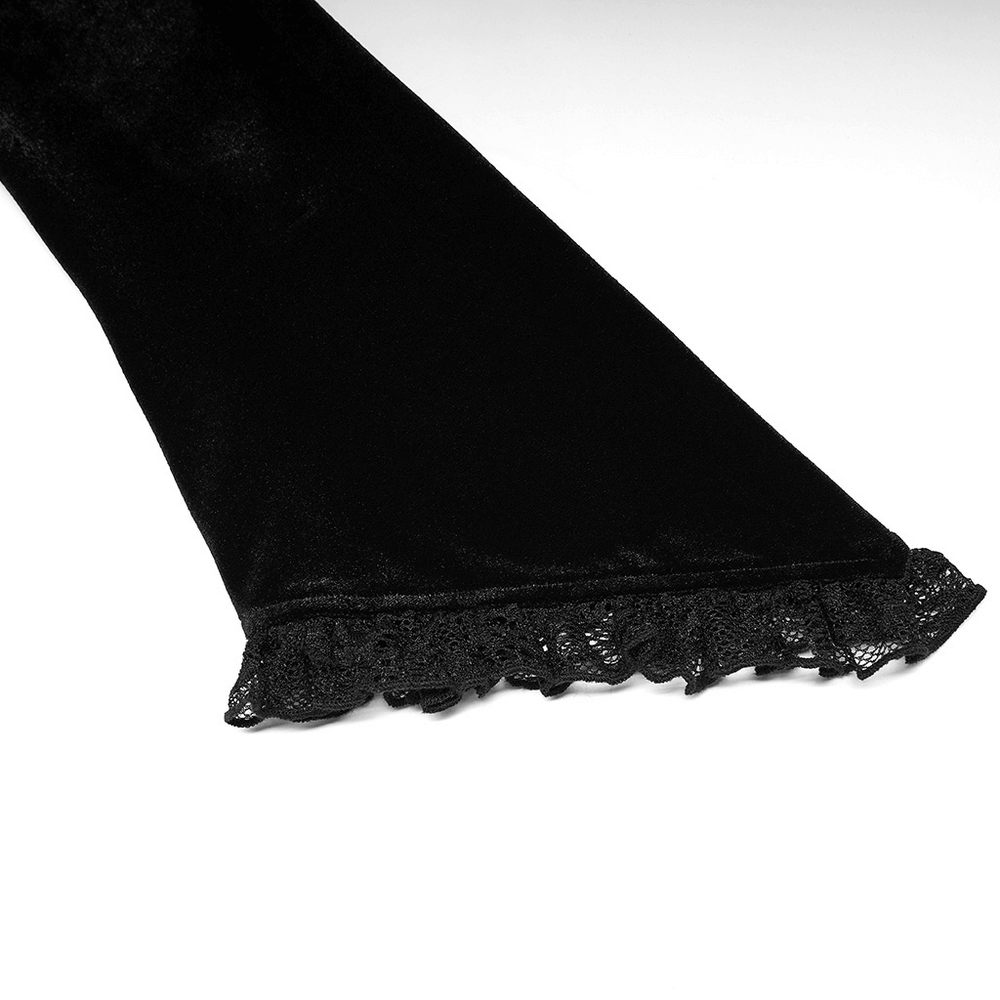 Close-up of black velvet dress hem with intricate lace trim, showcasing Gothic elegance and modern style.