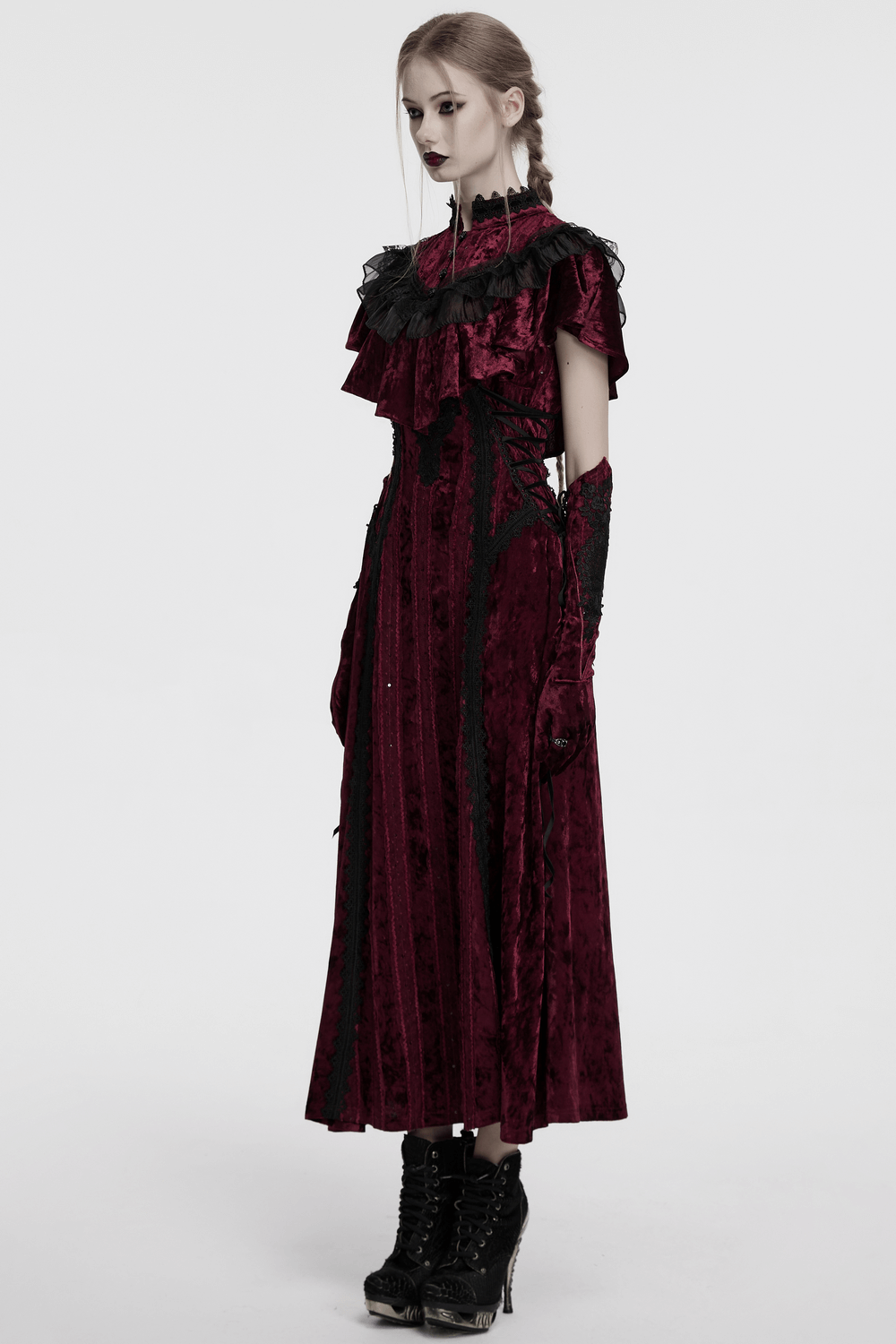 Elegant model in a velvet gothic dress with lace ruffles and gloves, showcasing vintage style and dark romance.