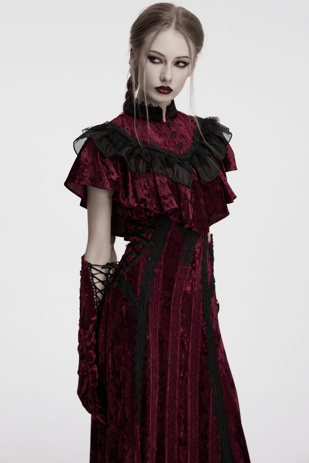 Elegant model in a velvet gothic dress with ruffled collar and black lace accents, showcasing vintage romance.