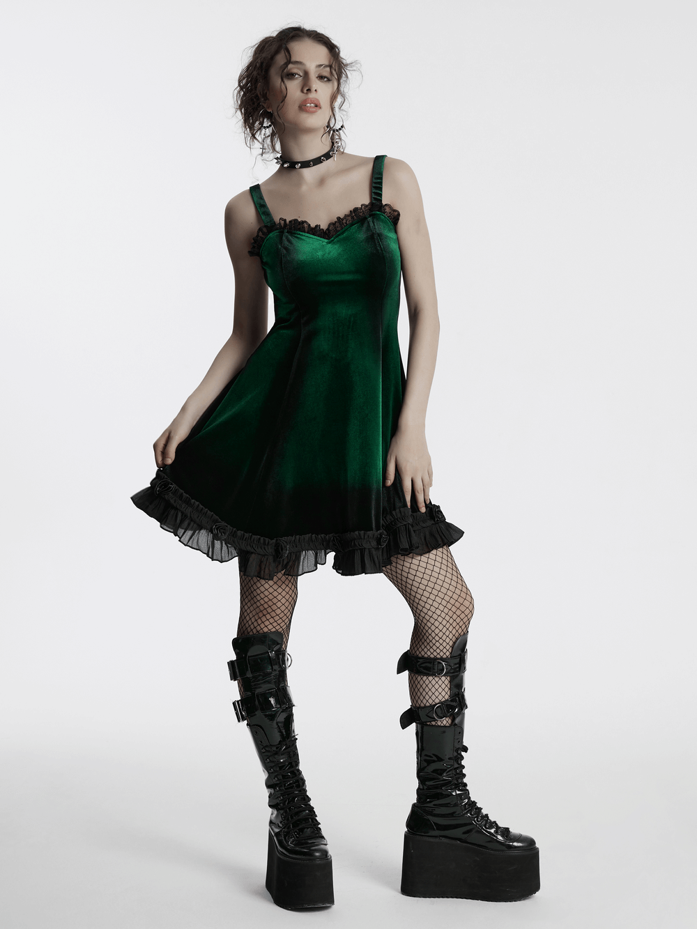 Goth velvet gradient printed dress in green with lace details, ruffled hem, and black chunky boots on model.