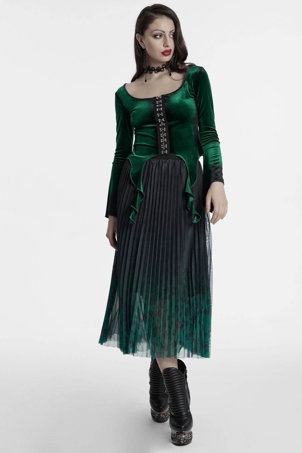 Elegant green velvet top with pleated black skirt and lace-up detail, showcasing gothic style and chic flair.