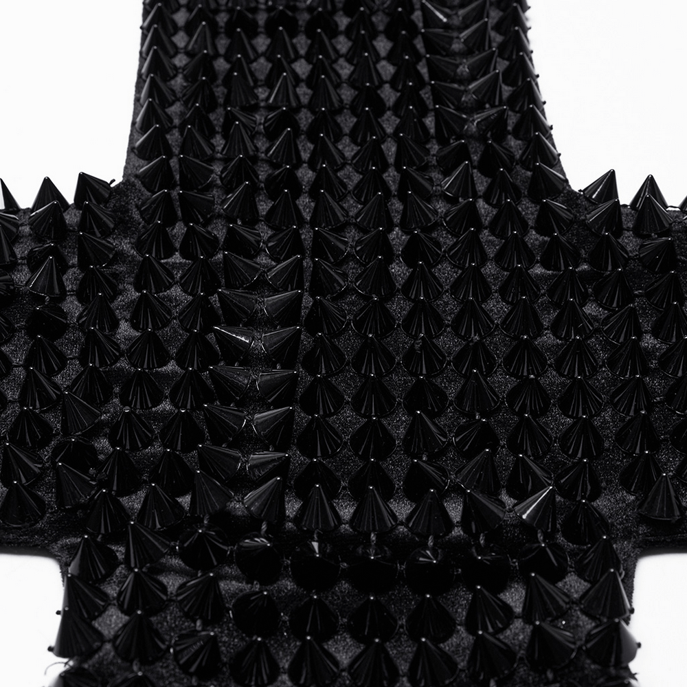 Close-up of black spiked rivets on a velvet halter top, showcasing gothic and futuristic design elements.