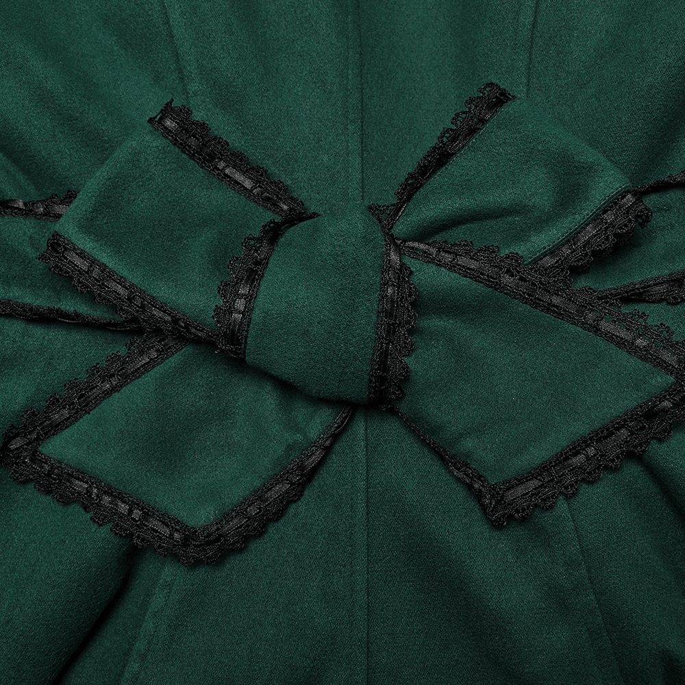 Close-up of a luxurious green velvet coat bow accent with black lace trim, showcasing vintage-inspired elegance.