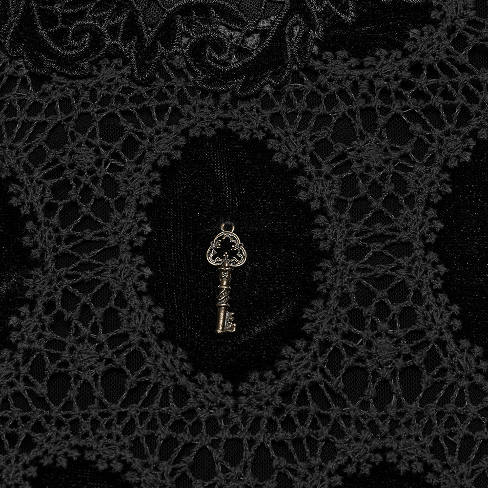 Close-up of a black velvet fabric featuring intricate lace and a key charm detail for a unique look.