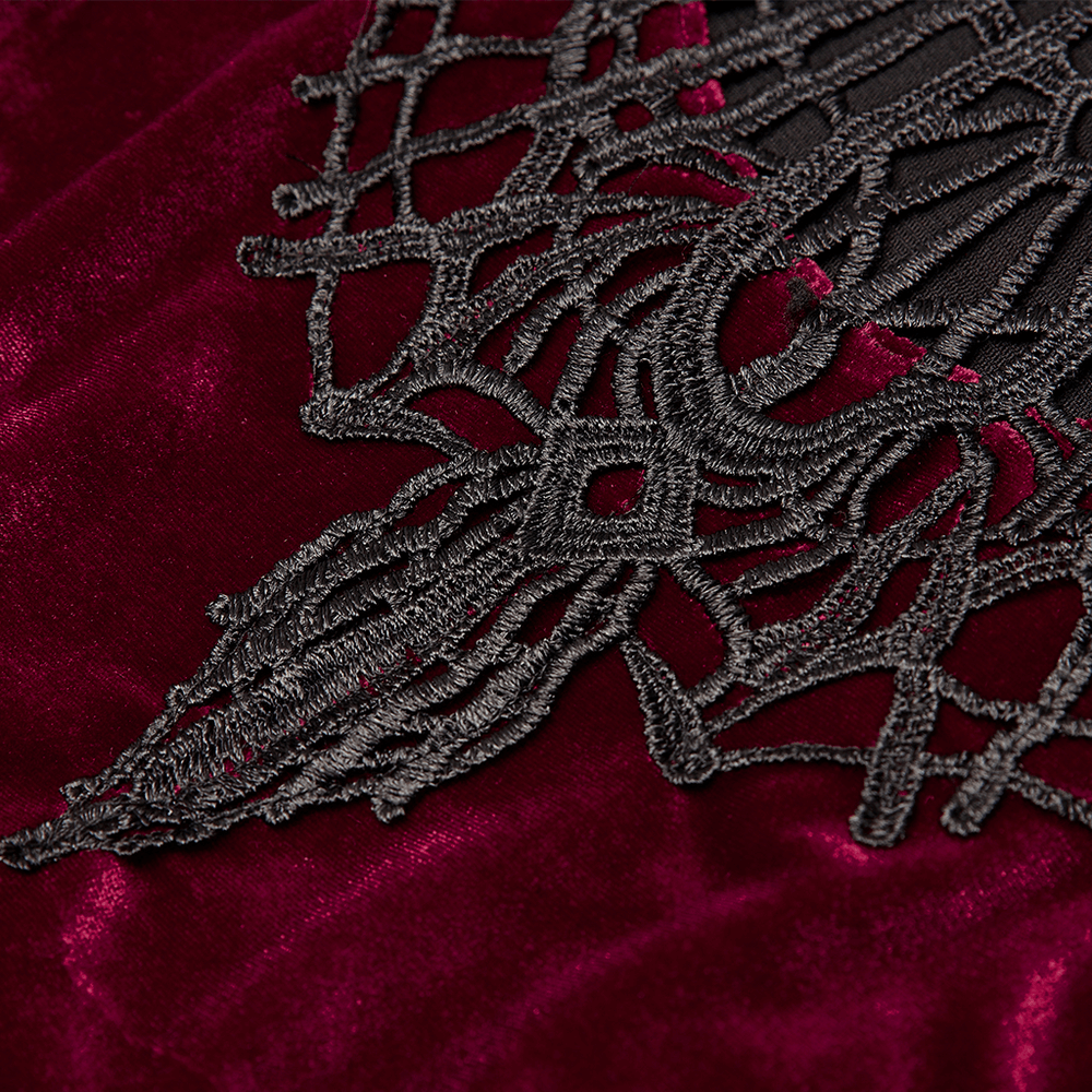 Close-up of intricate lace detailing on luxurious burgundy velvet fabric, showcasing gothic elegance.