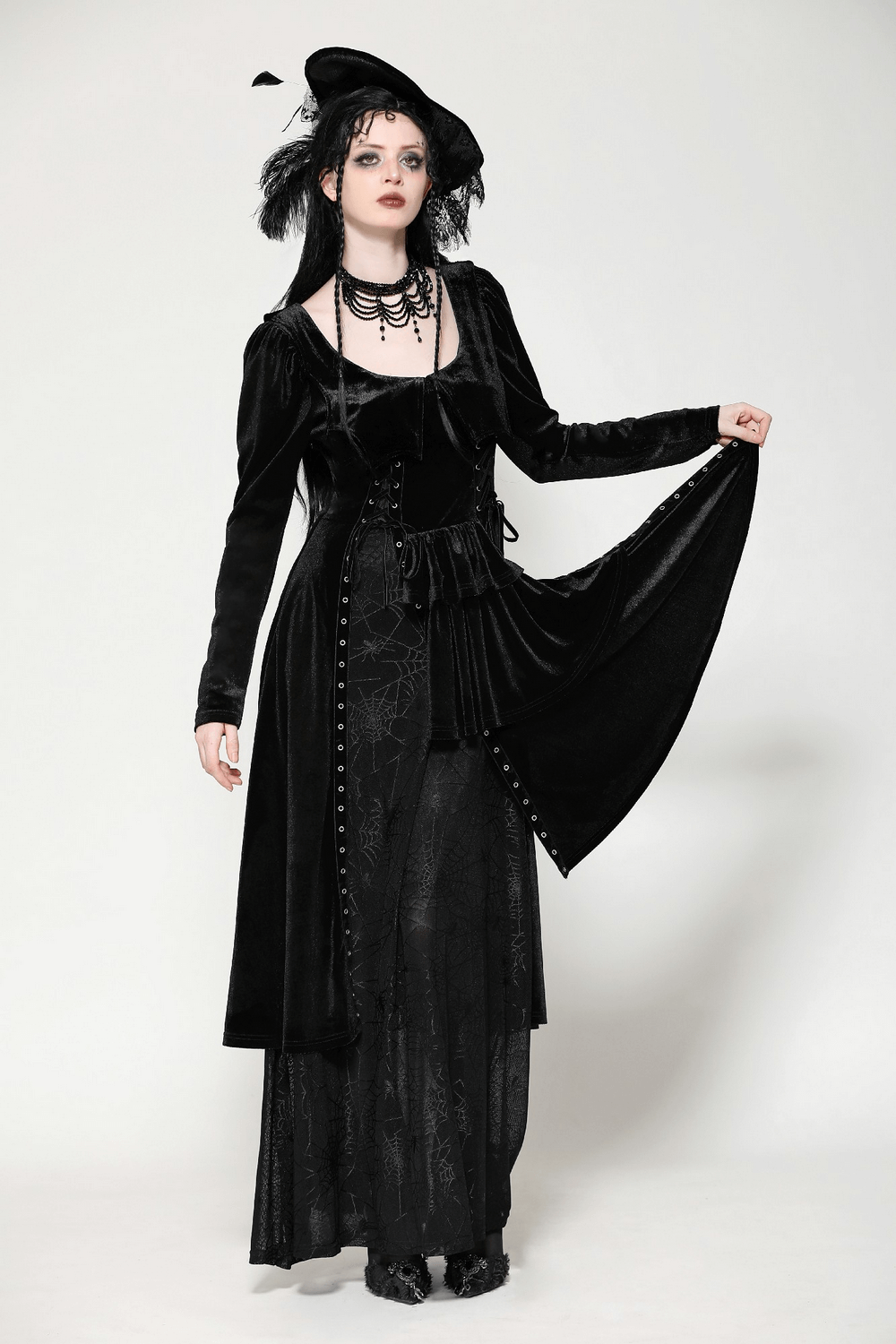 Elegant gothic model in a black velvet lace-up dress with mesh panels and spiderweb patterns, perfect for Victorian themes.