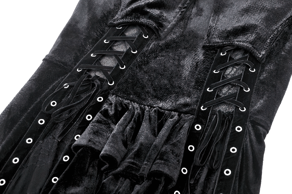 Close-up of a black velvet lace-up gothic dress with mesh panel and grommet details, showcasing its intricate design.