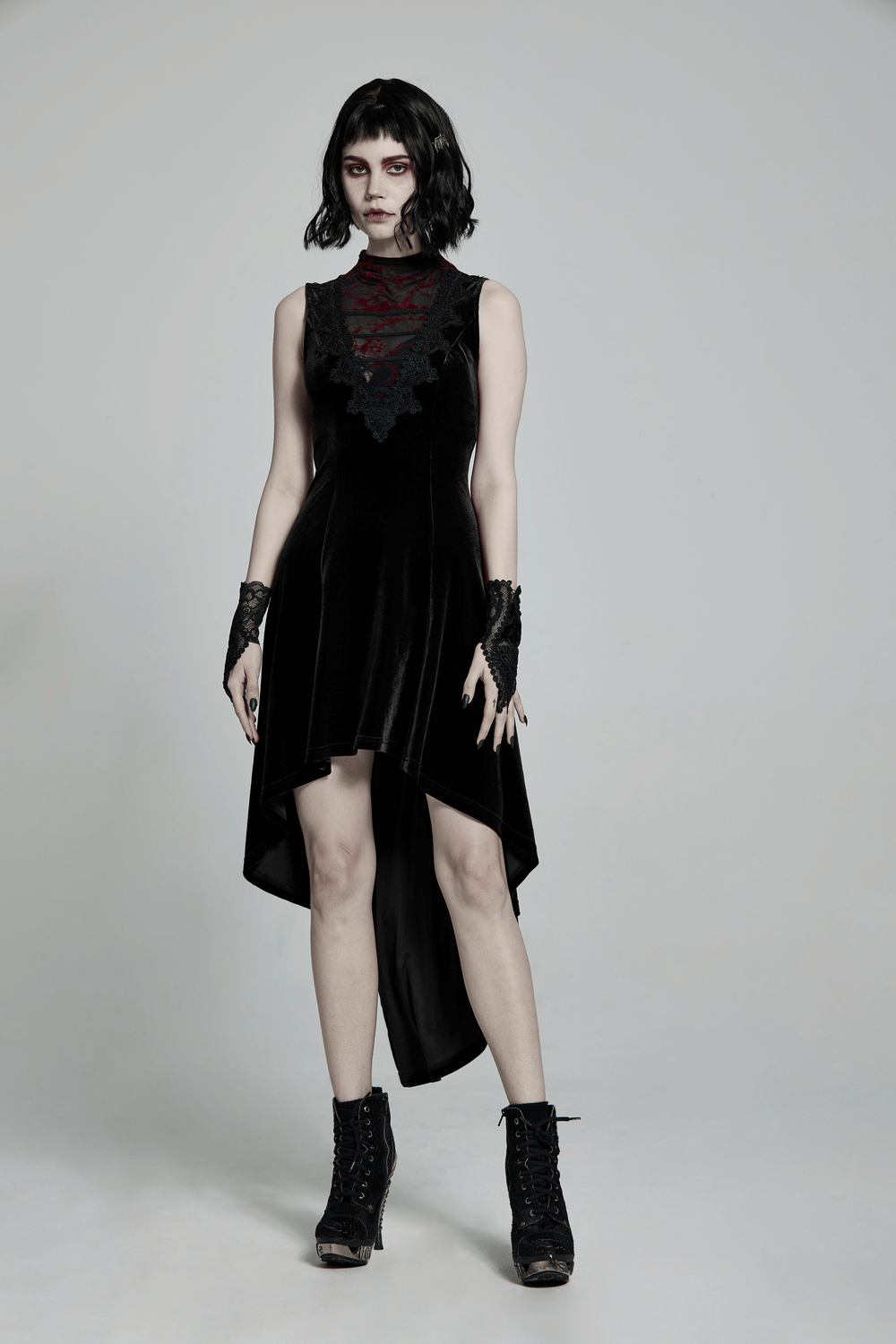 Gothic sleeveless high-low dress in velvet with lace trim and mesh details, paired with lace gloves and boots.