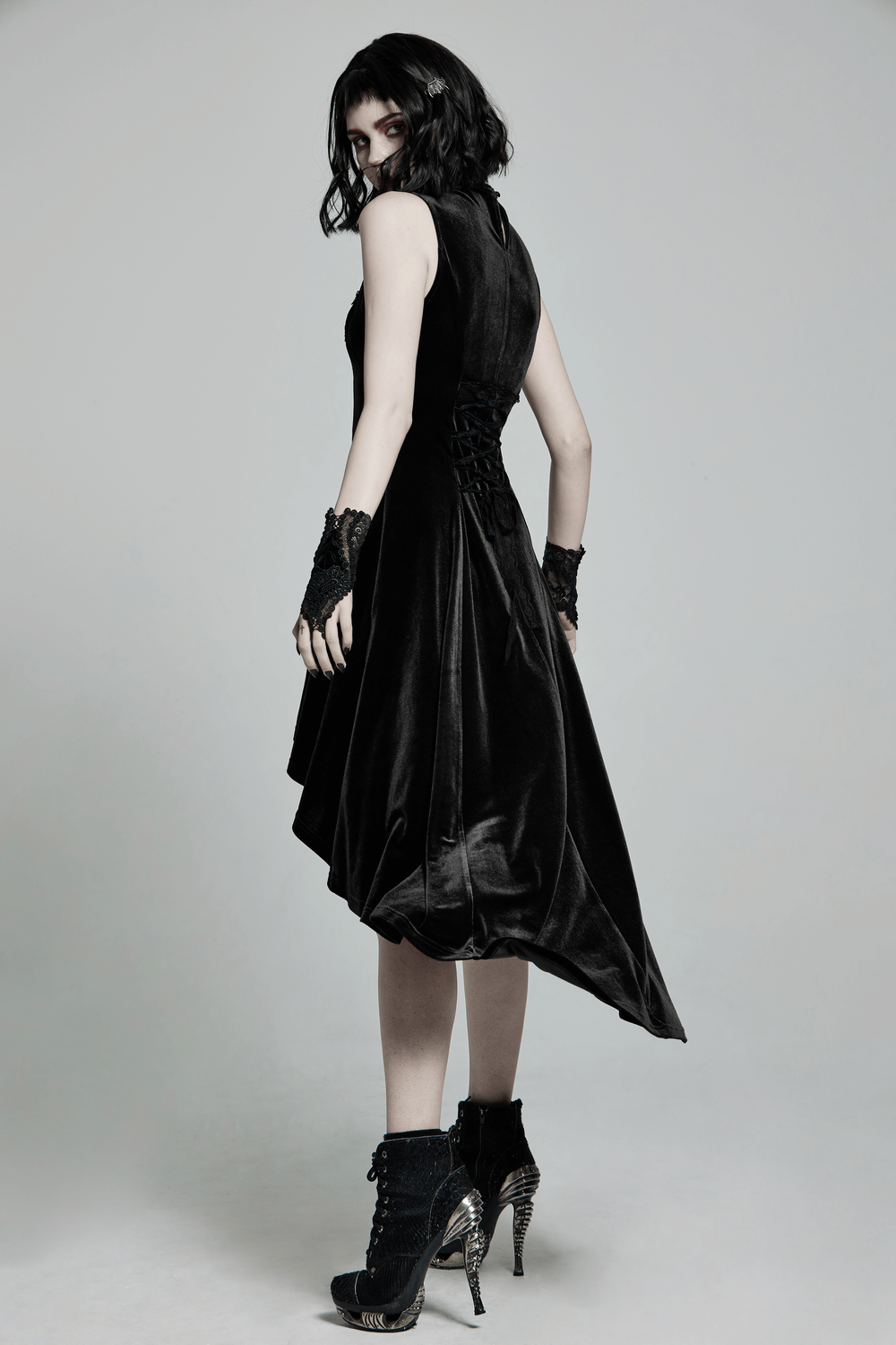 Elegant Gothic sleeveless high-low dress in black velvet with lace details and irregular hem.