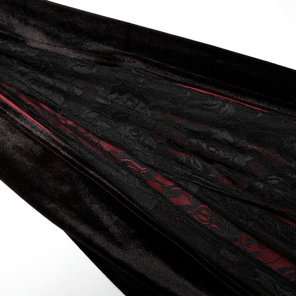 Close-up of velvet fabric with intricate black lace and red gradient, showcasing elegance and gothic style.