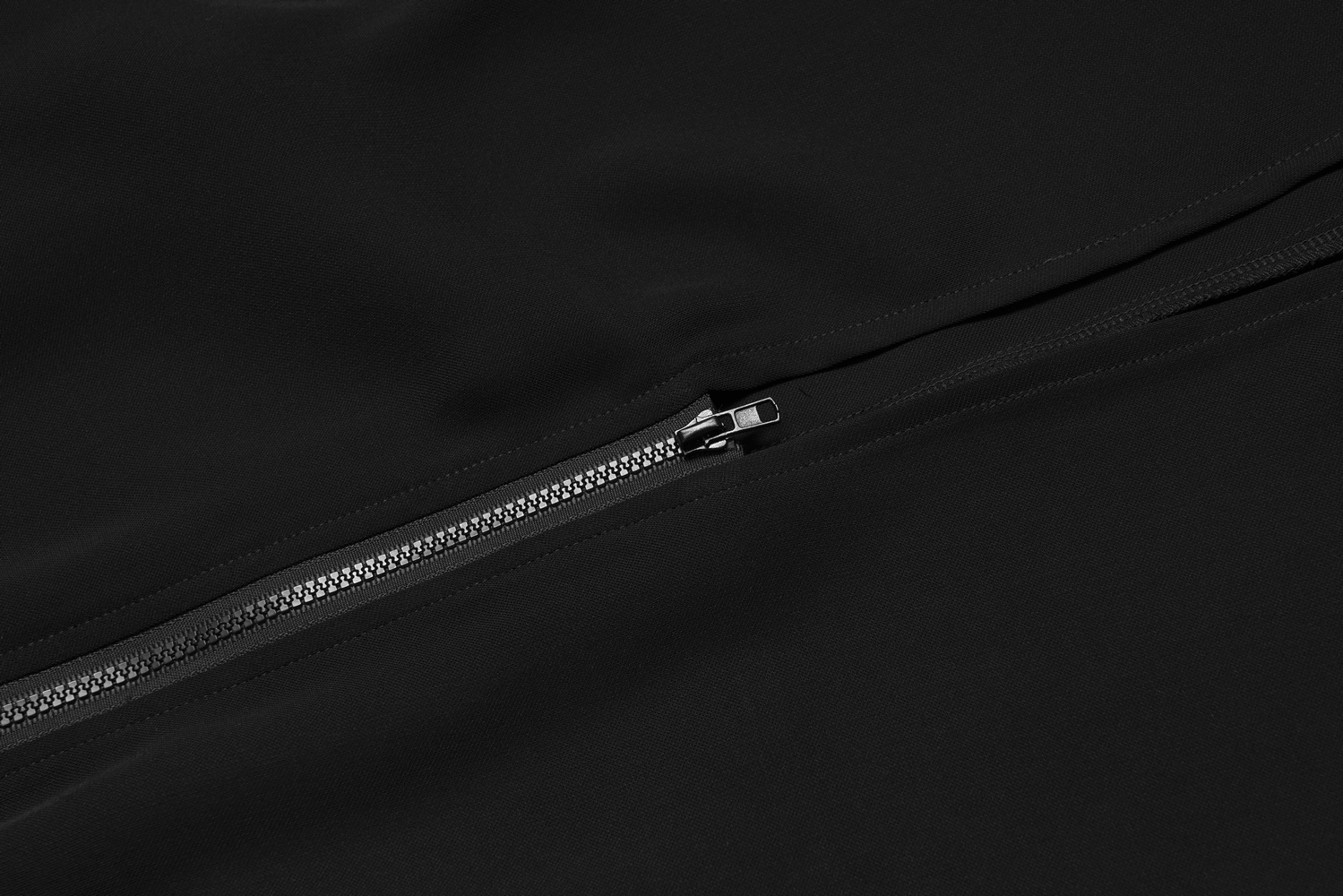 Close-up view of a sleek side zipper detail on a versatile black A-Line midi skirt.