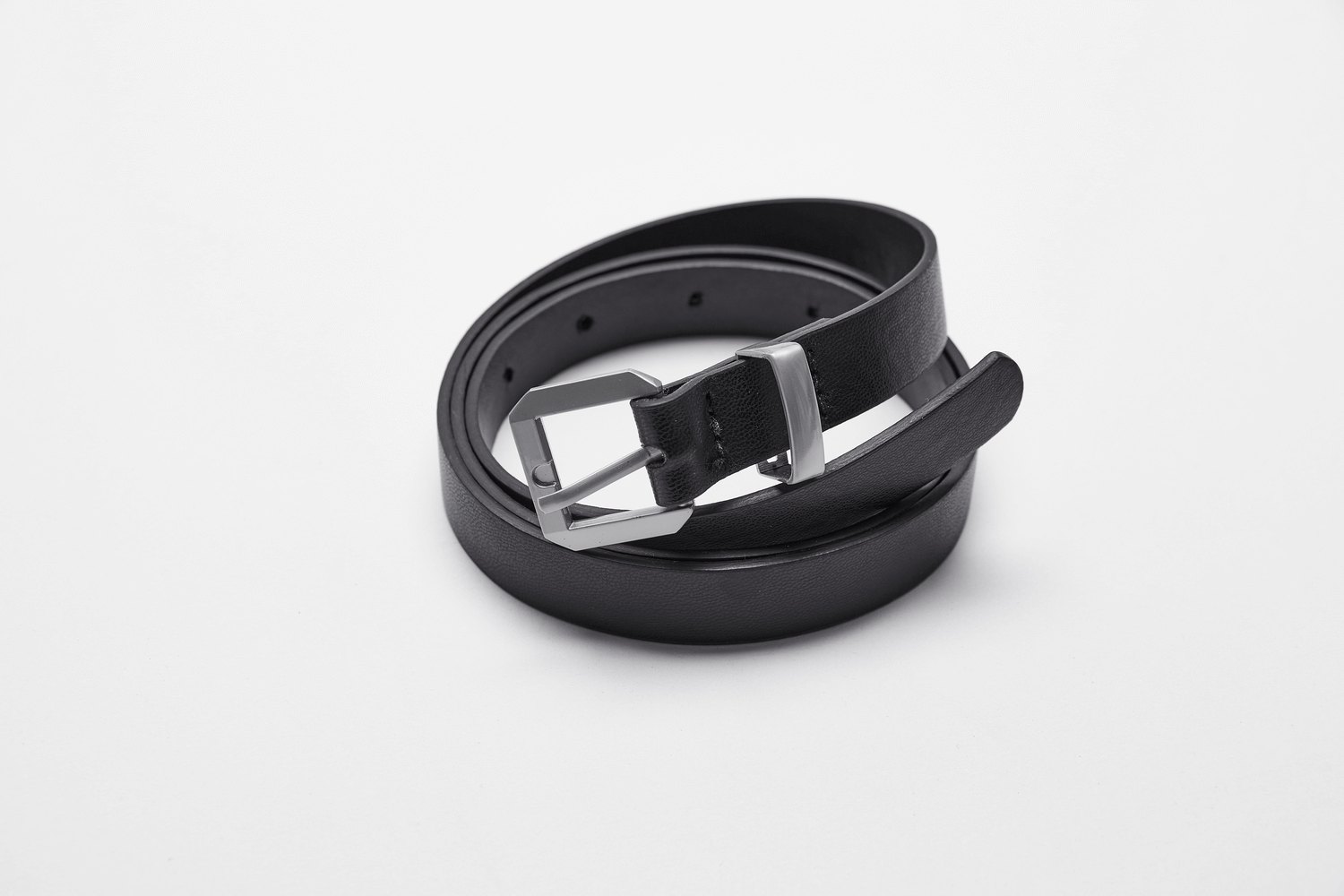Stylish black leather belt with a silver buckle, laying flat for a minimalist look.