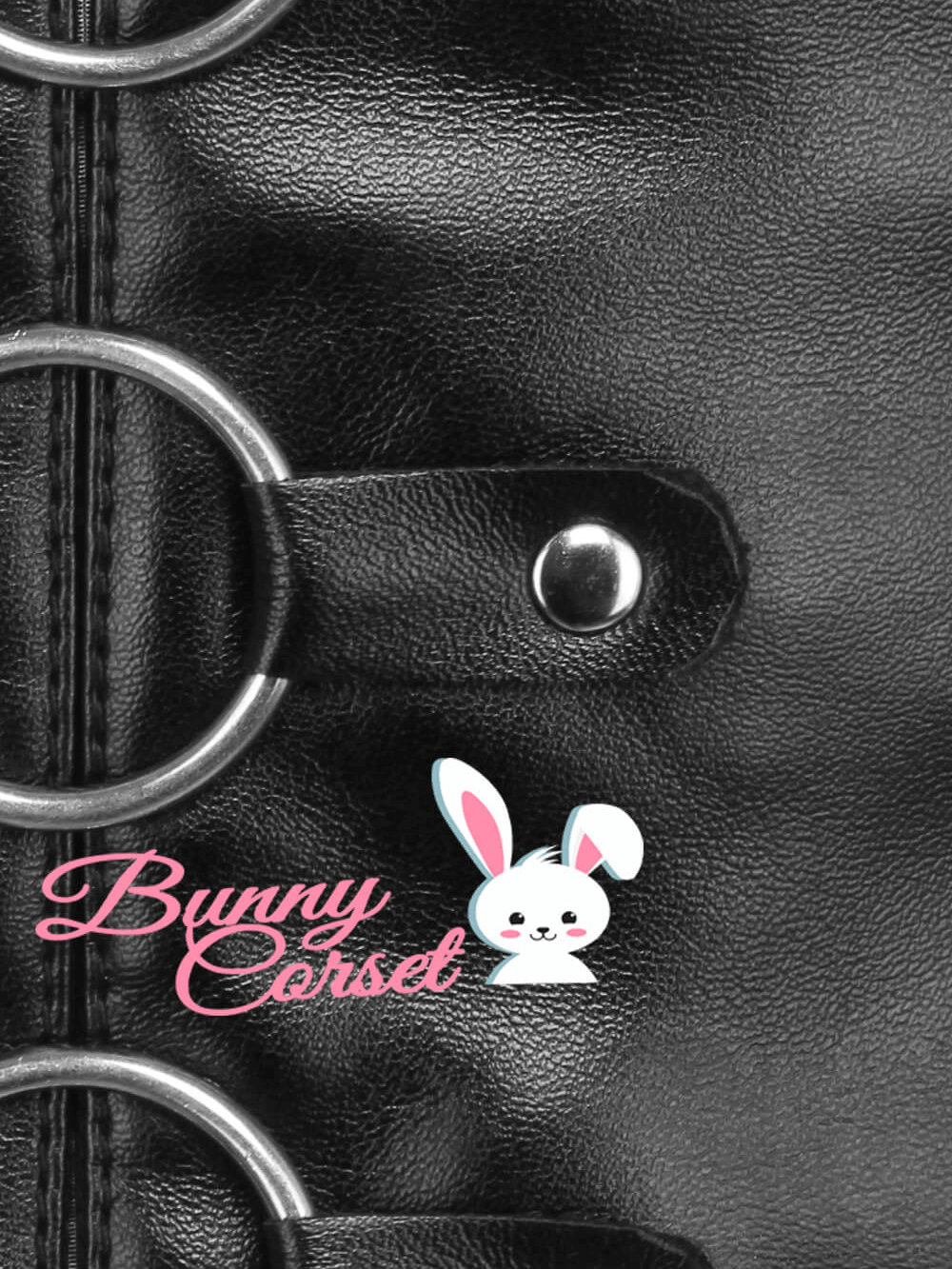 Close-up of a faux leather corset belt featuring silver rings and a playful Bunny Corset logo.