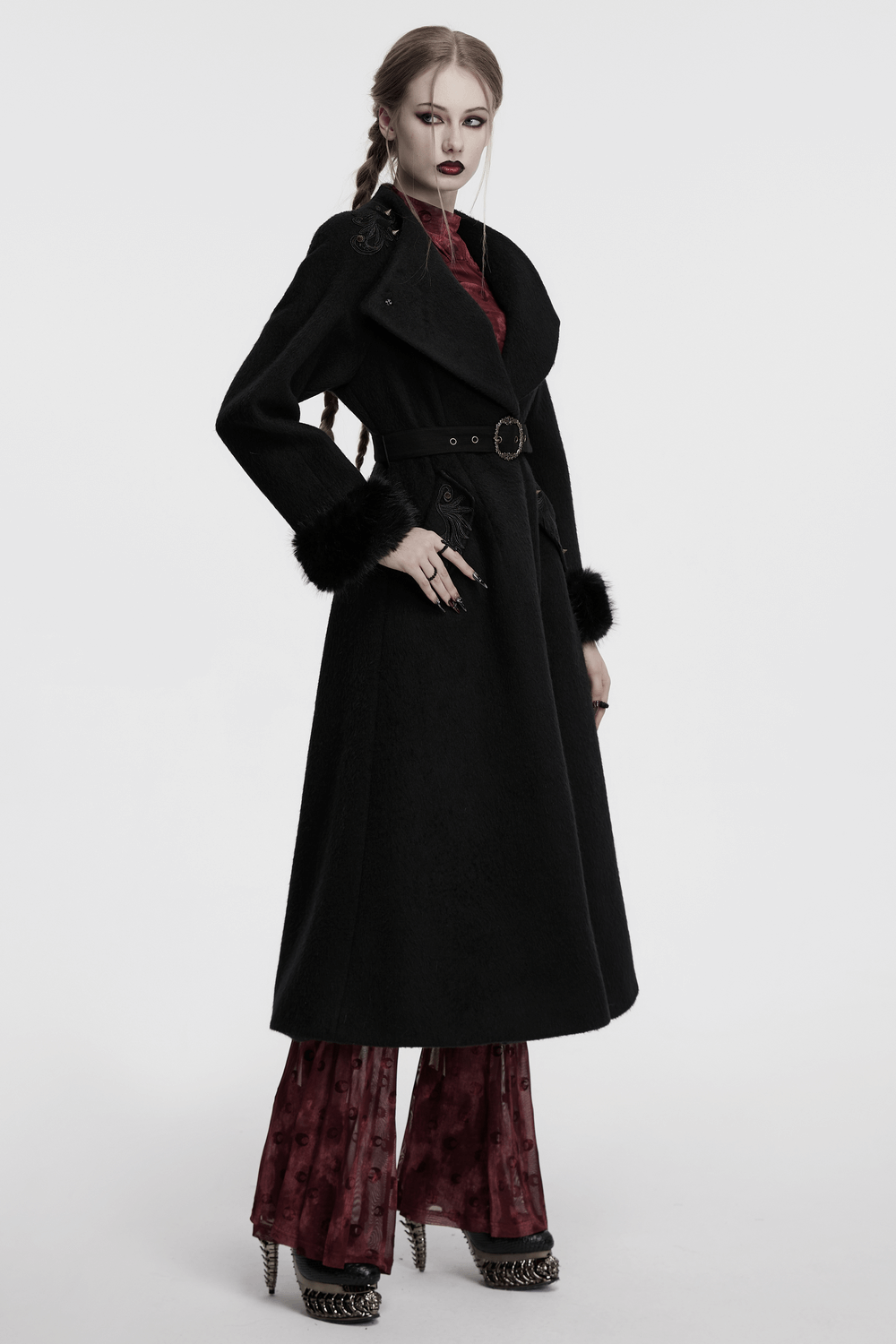 Victorian black long coat with belt and fur cuffs, adorned with gothic style appliques and studs, showcasing a dramatic silhouette.