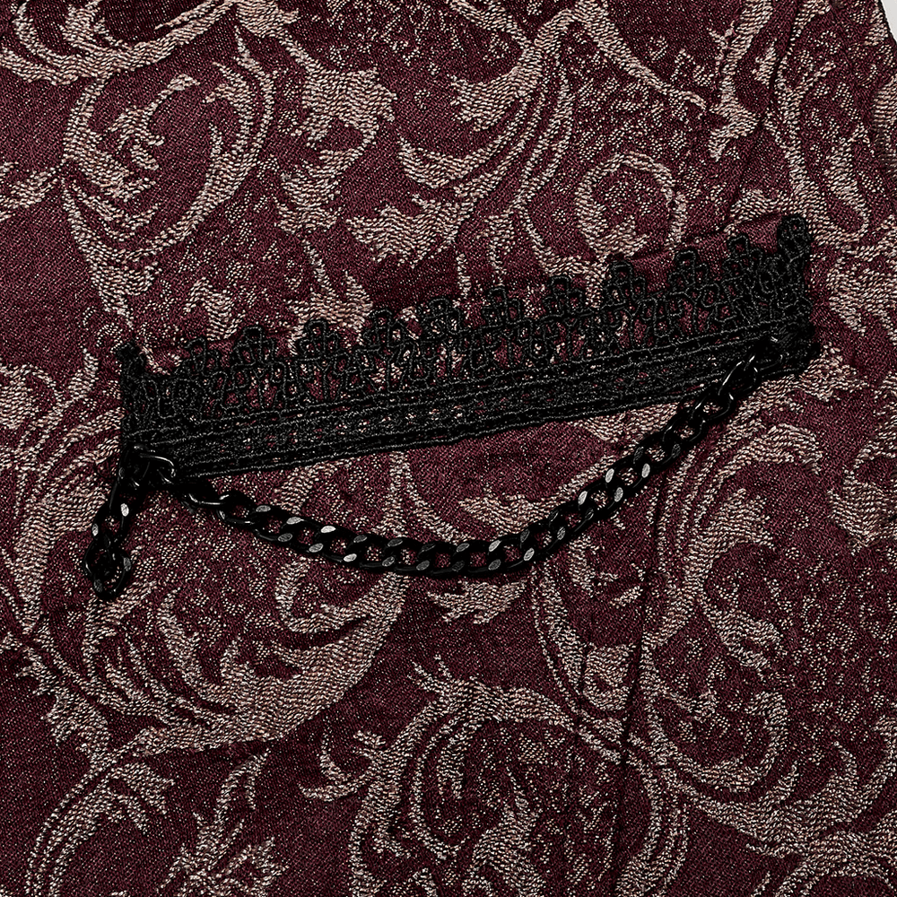Close-up of elegant burgundy jacquard fabric with intricate black lace trim and chain detail.