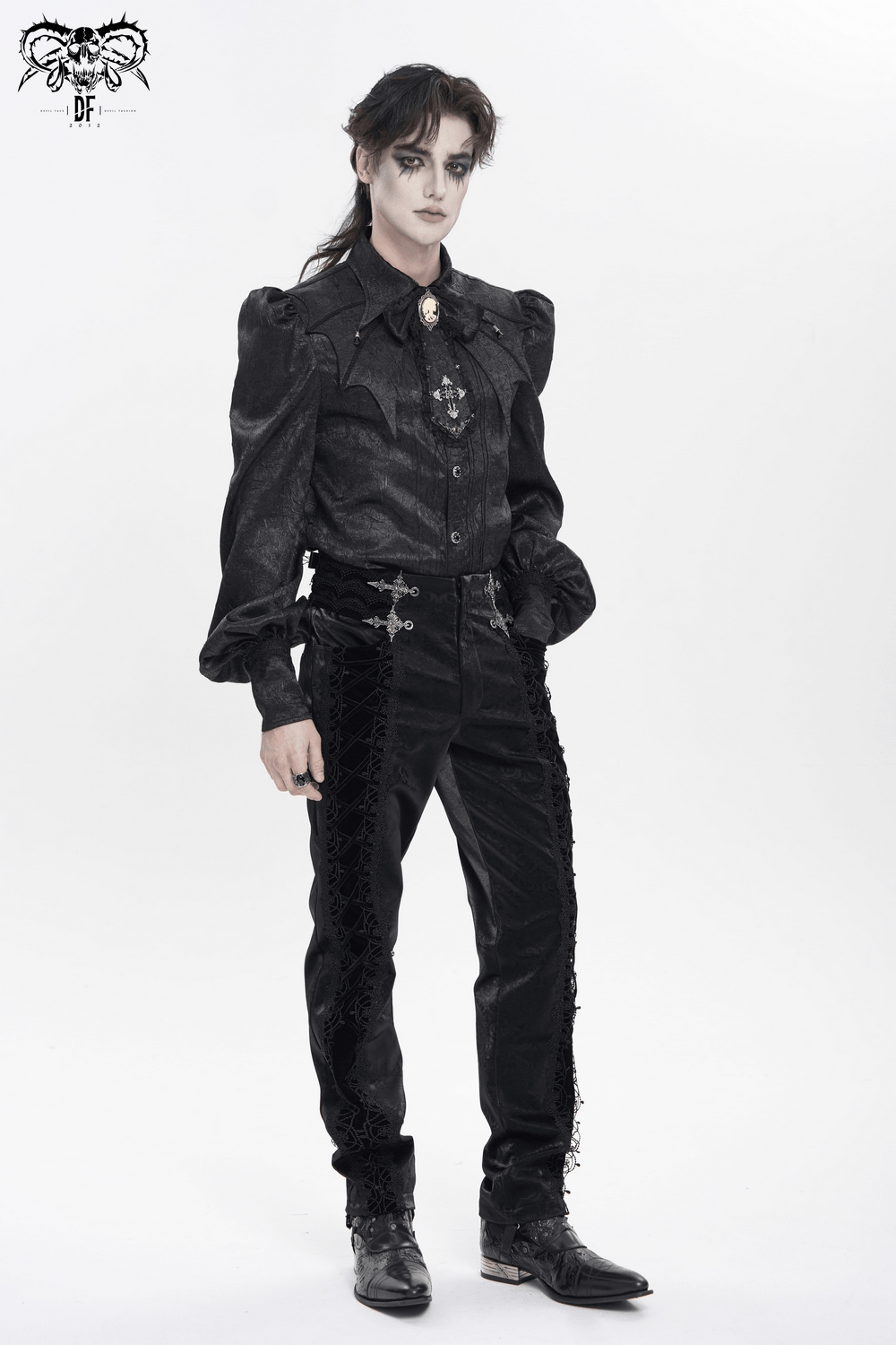 Victorian Goth Button Shirt With Cameo and Cross Brooch worn by model in black puff sleeve shirt and tailored pants.