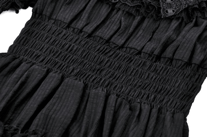 Close-up of Victorian Gothic black lace dress with ruffled detailing and smocked waist, showcasing elegant fabric texture.