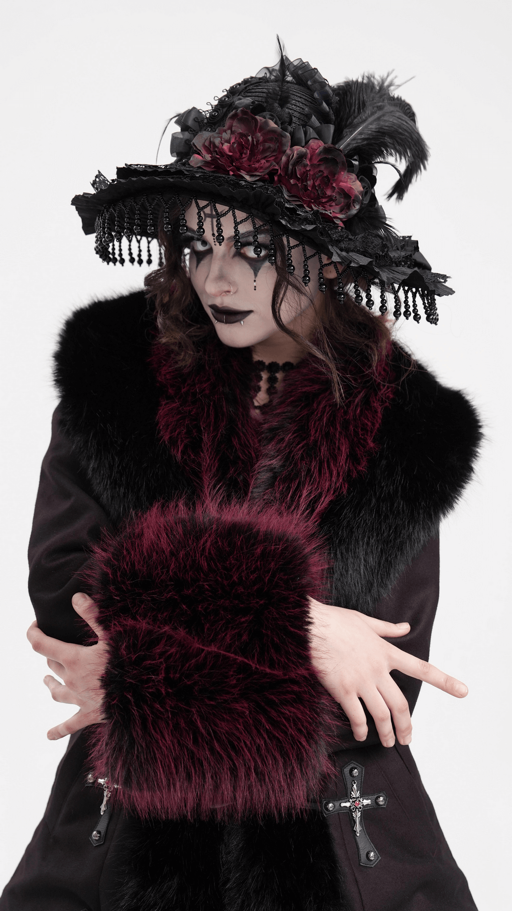 Victorian Gothic hat with feathers, lace, and beaded trim worn by a model in dramatic attire, showcasing gothic fashion.