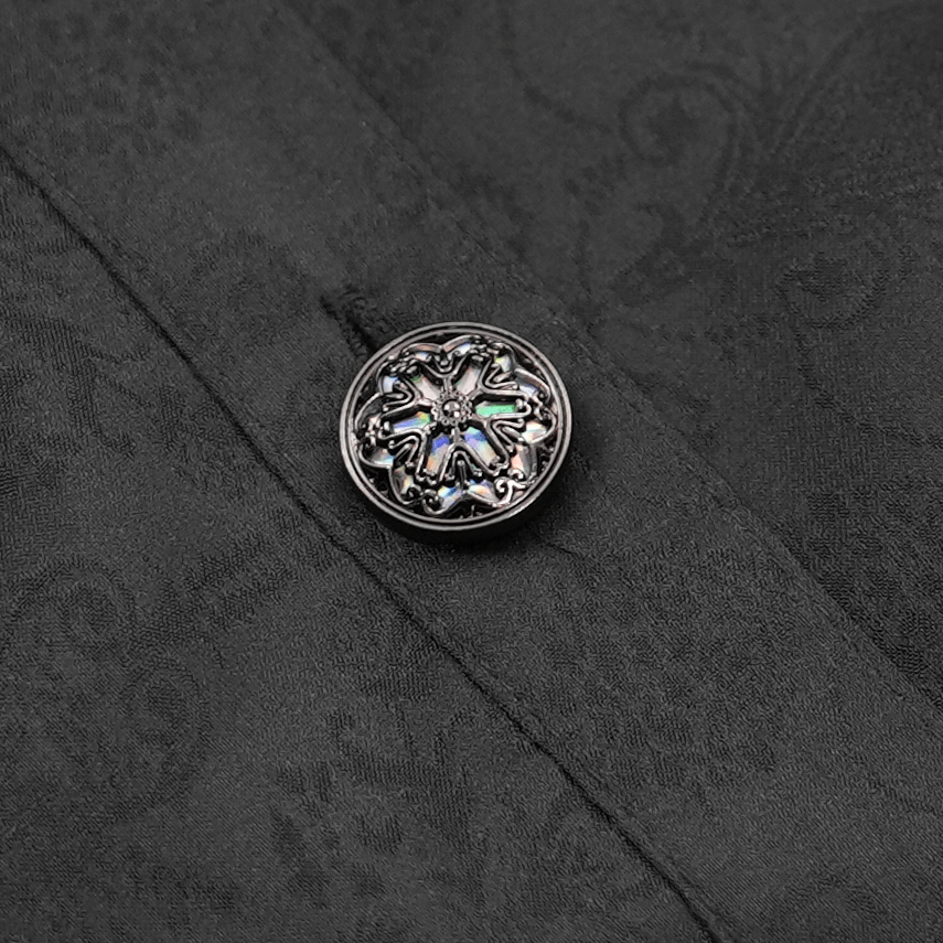 Intricate silver Victorian button on a black lace blouse fabric, showcasing gothic elegance and fine detailing.