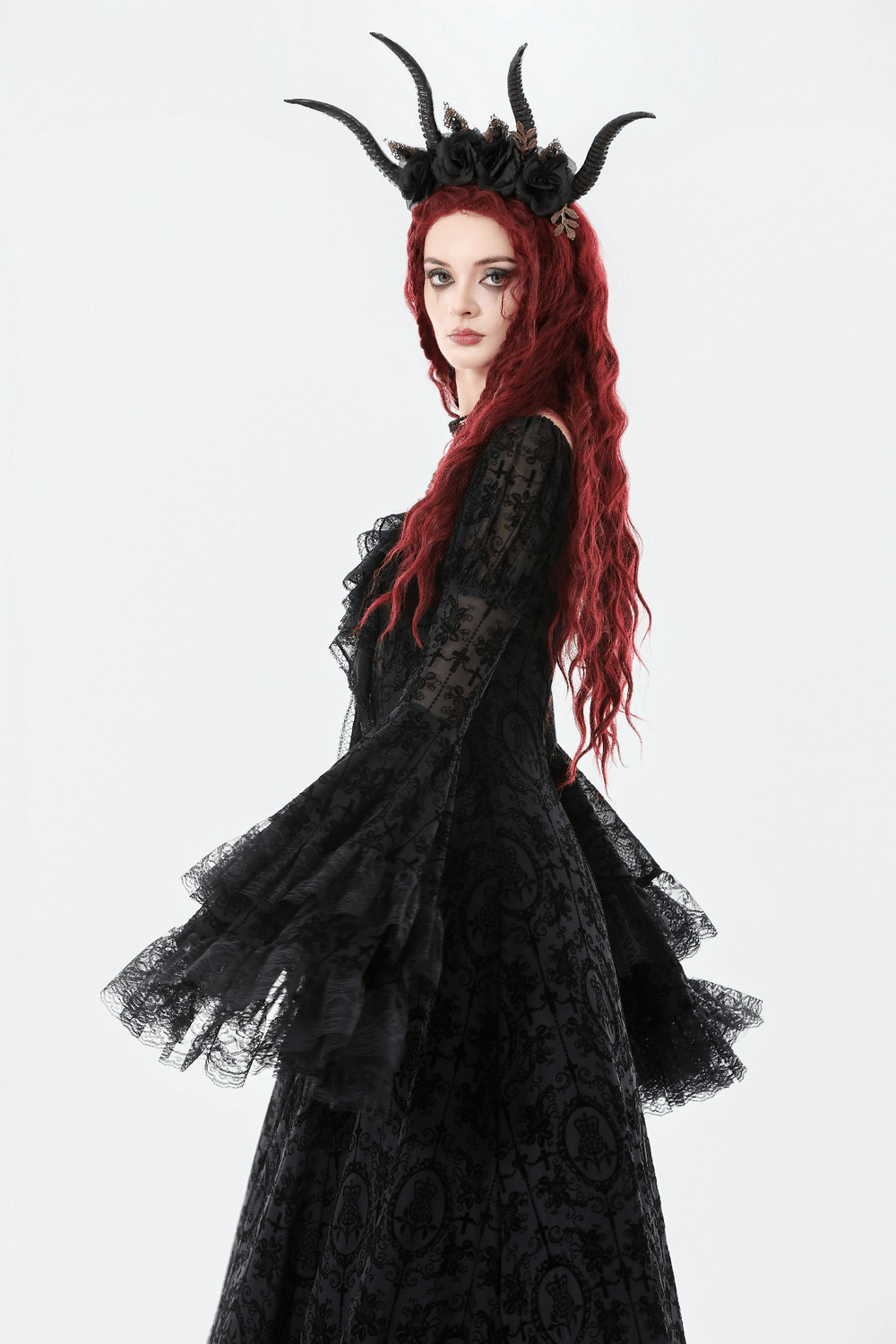 Victorian Gothic Lace Maxi Dress with Bell Sleeves worn by a model with red hair and a unique horned headpiece.