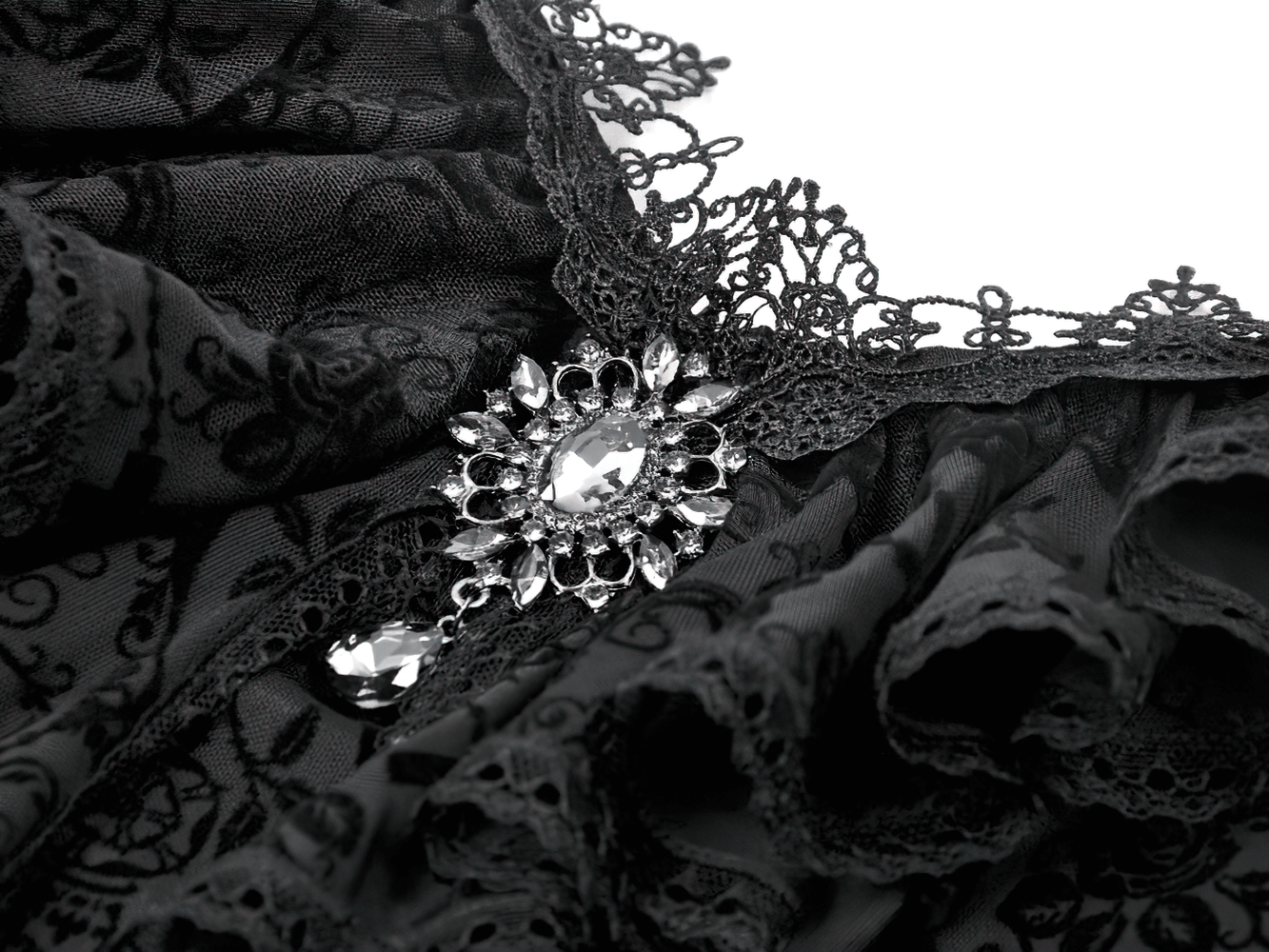 Close-up detail of Victorian Gothic Lace Maxi Dress with Bell Sleeves showcasing intricate lace and a decorative brooch.