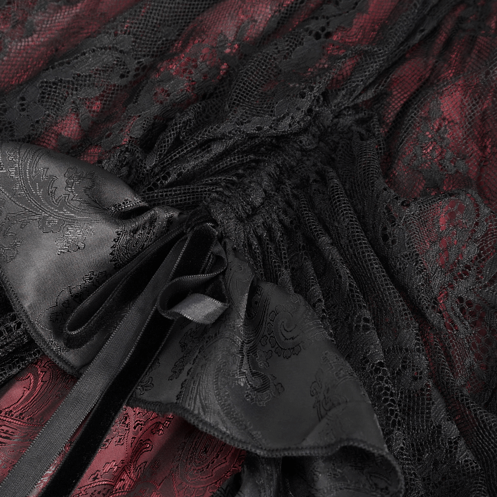 Close-up of Victorian Gothic lace skirt with black and red fabric, featuring ruffled layers and satin bows.