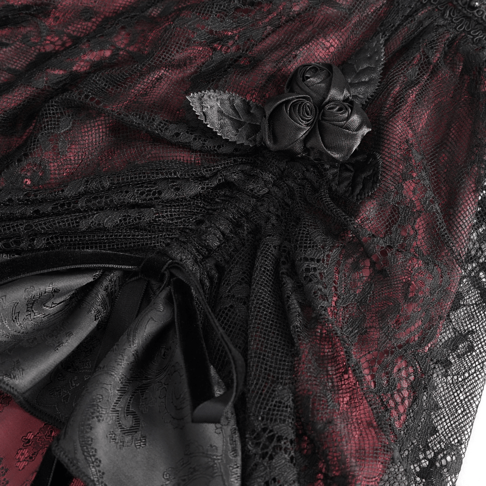 Close-up of black and red Victorian Gothic lace skirt with ruffled layers and satin bow accents.