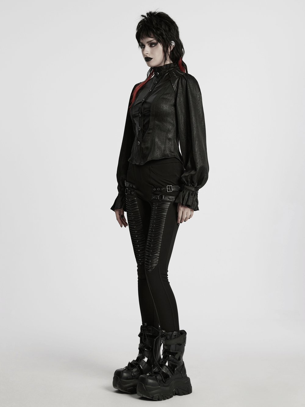 Victorian gothic lace-up blouse with puff sleeves and faux leather details, styled with edgy black leggings and boots.