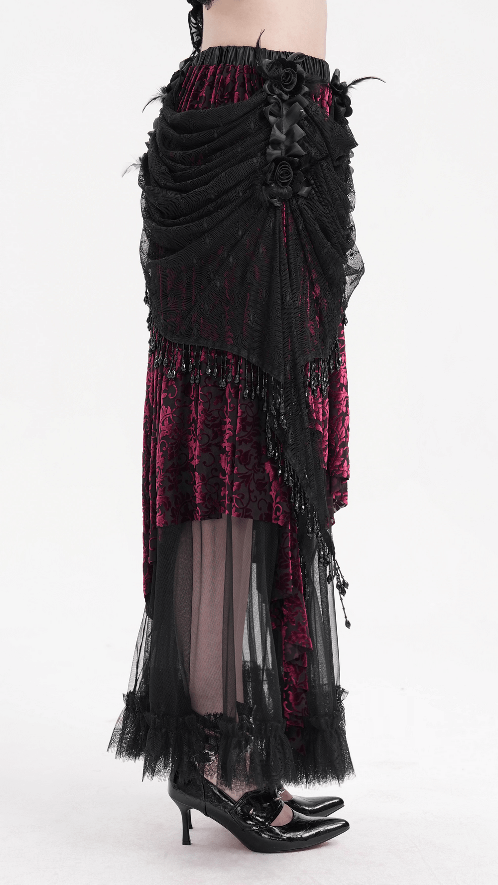 Side view of a Victorian gothic layered skirt with lace, beads, and rose embellishments, featuring a deep red underlayer.