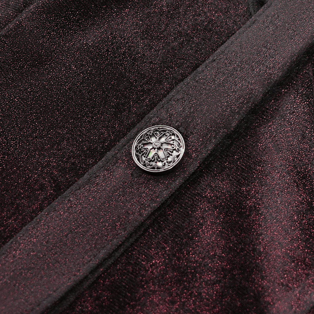 Close-up of decorative button on Victorian gothic velvet blouse, showcasing intricate design and rich texture.