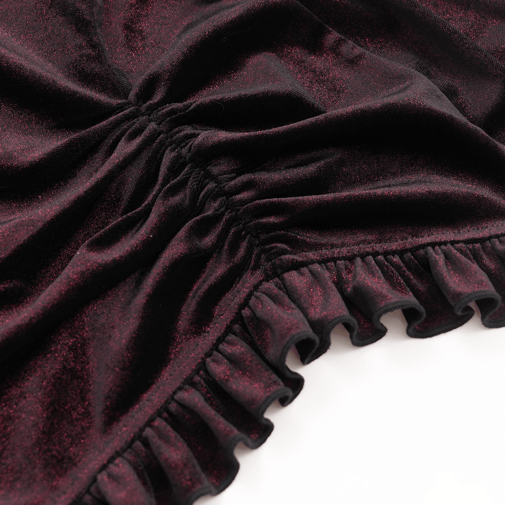 Close-up of rich burgundy velvet fabric with gathered texture and ruffled edges, showcasing gothic elegance.