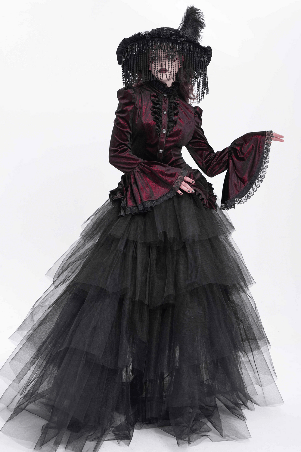 Victorian Gothic girl in a velvet and tulle layered gown, showcasing dramatic bell sleeves and lace details.