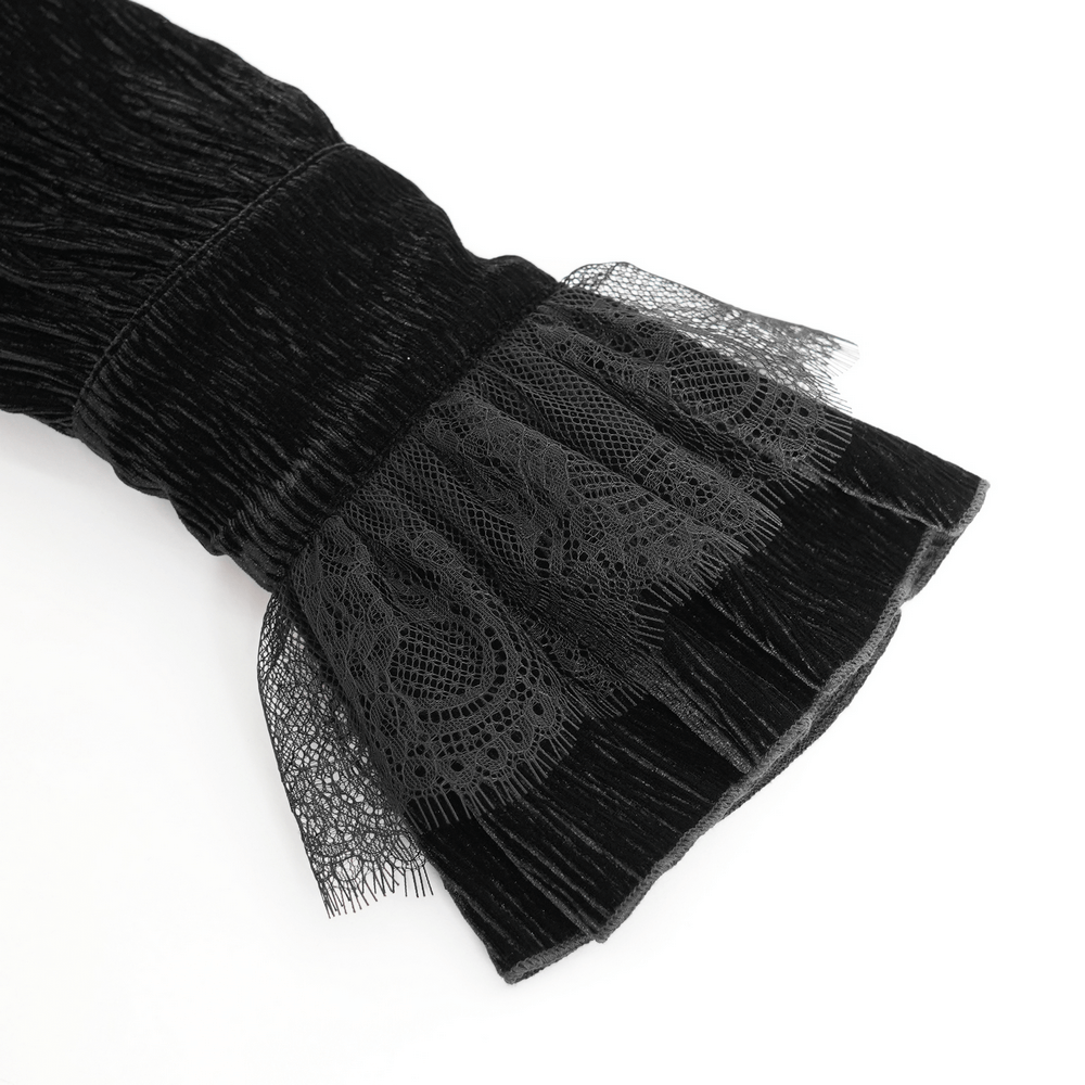 Close-up of Victorian gothic velvet shirt cuff with lace ruffles and textured black fabric for dramatic flair.