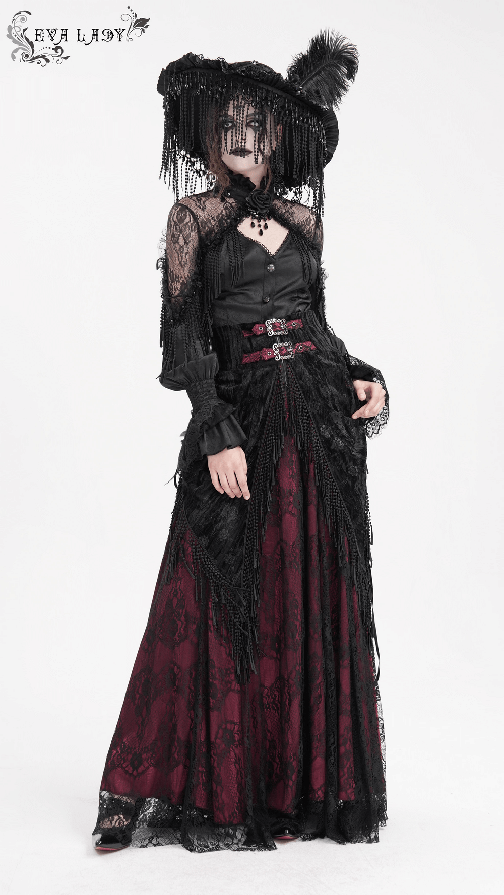 Gothic Victorian high-waist skirt with lace overlay, tassel details, and deep magenta lining, paired with a dark top and hat.