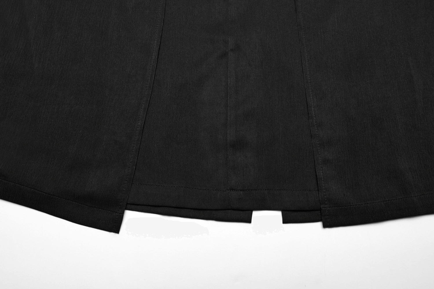 Close-up of the hem and rear slit of a Victorian-inspired black A-line maxi skirt with pockets.