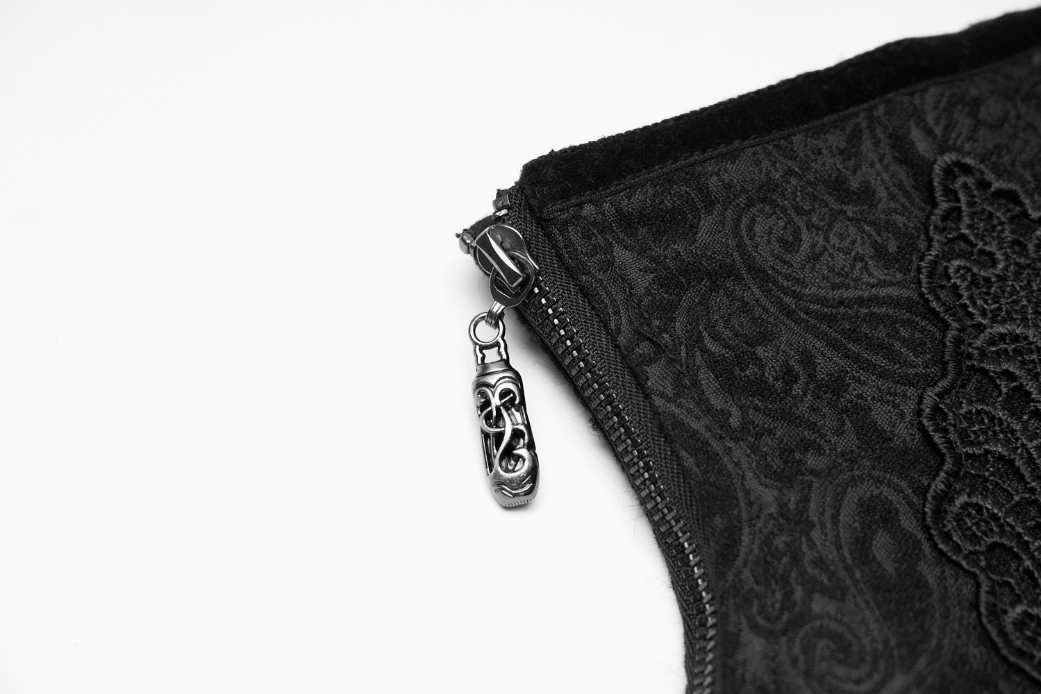 Close-up of the ornate zipper on a Victorian-inspired black brocade corset with intricate lace detailing.