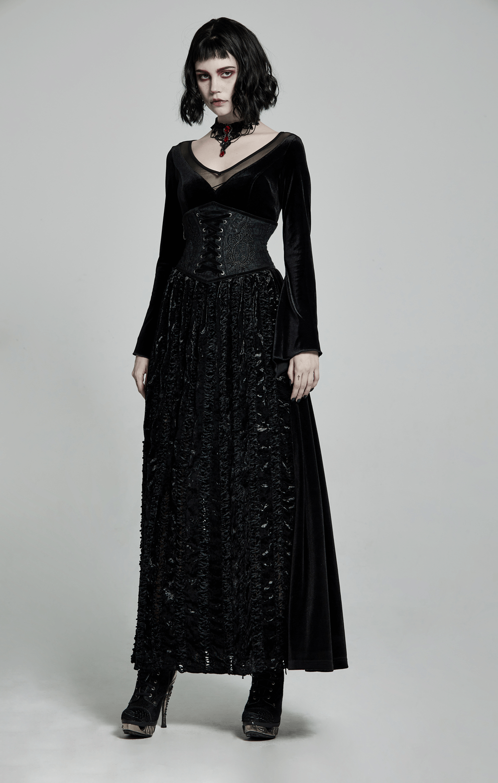Victorian-inspired model in black brocade gothic full corset and elegant long dress with lace details.
