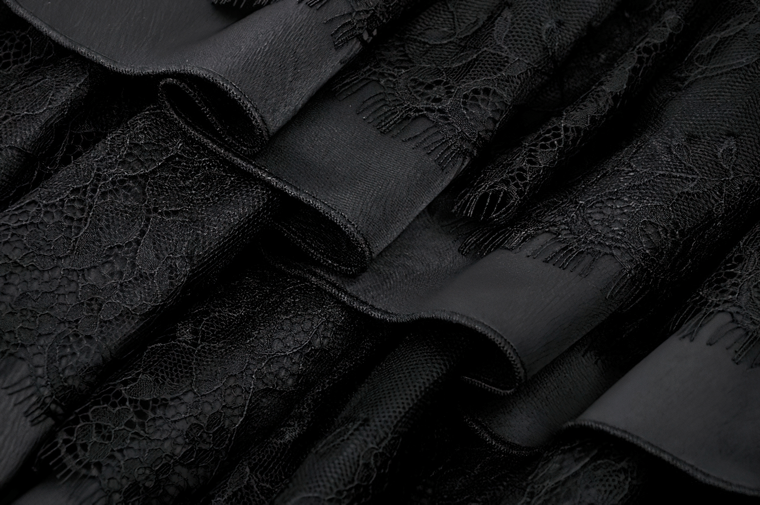 Elegant black lace fabric showcasing intricate details and soft ruffles for a Victorian-inspired mini dress.