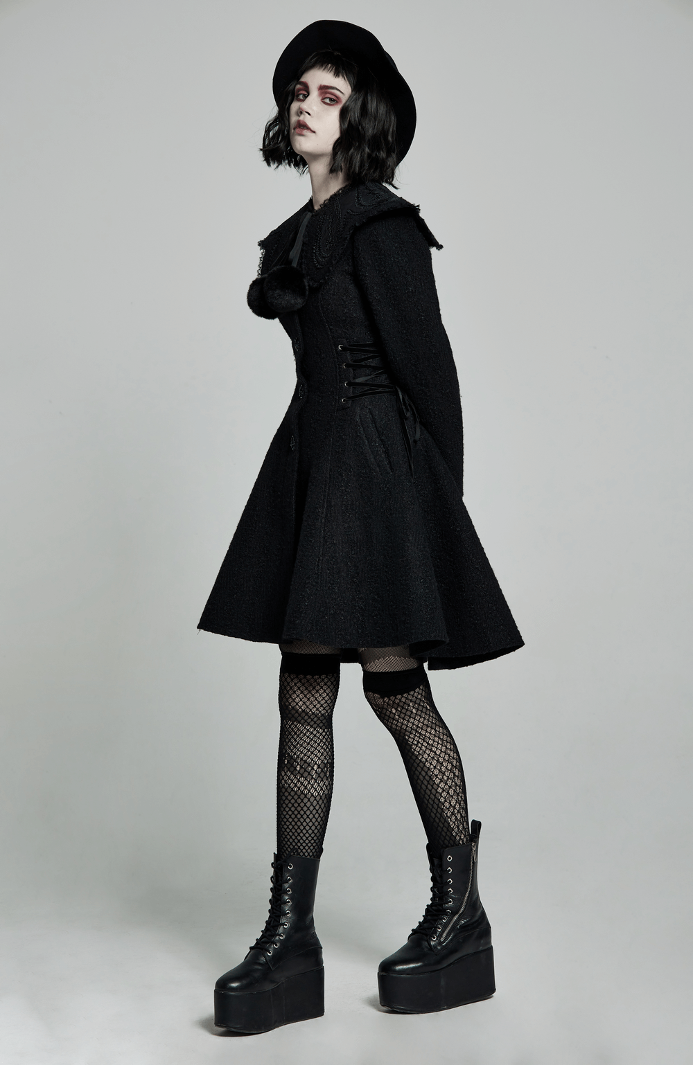 Gothic model showcasing a Victorian-inspired black woollen coat with a detachable fur collar and retro rose buttons.