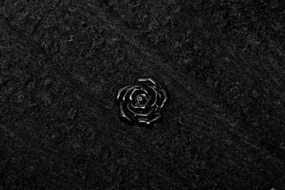 Elegant hand-sewn black rose button on a Victorian-inspired woollen coat featuring intricate jacquard fabric.