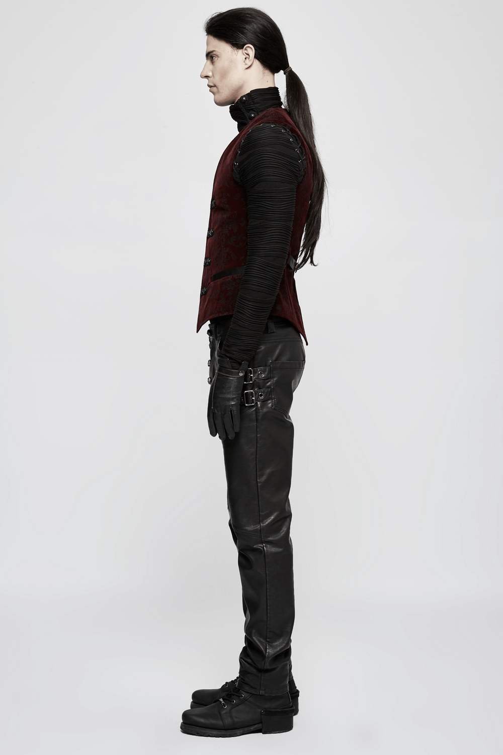 Side view of a man in a Victorian-inspired gothic velveteen waistcoat and leather pants, showcasing dark elegance.