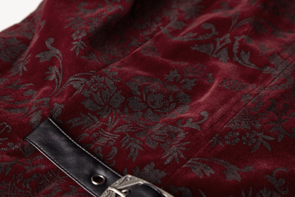 Close-up of a burgundy velveteen waistcoat featuring intricate gothic floral patterns and a stylish black buckle.