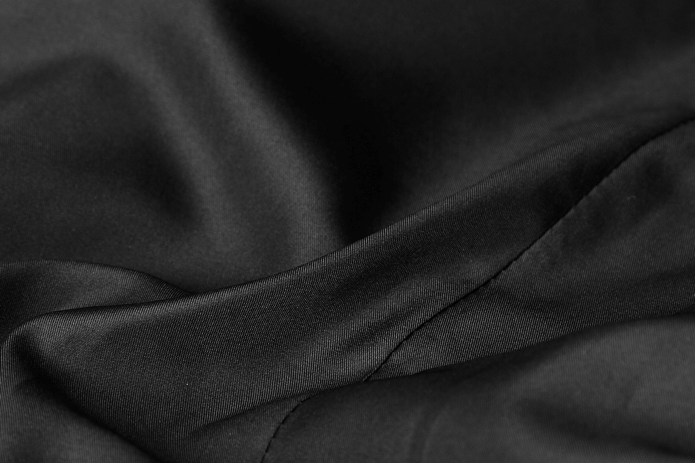 Close-up of luxurious black velveteen fabric, showcasing its soft texture and elegant drape for a gothic aesthetic.